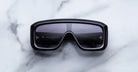 Jacques Marie Mage Pausa black rectangular sunglasses with dark lenses, top view.