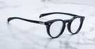 Jacques Marie Mage Percier eyeglasses with clear lenses and round black frames, shown from the front.