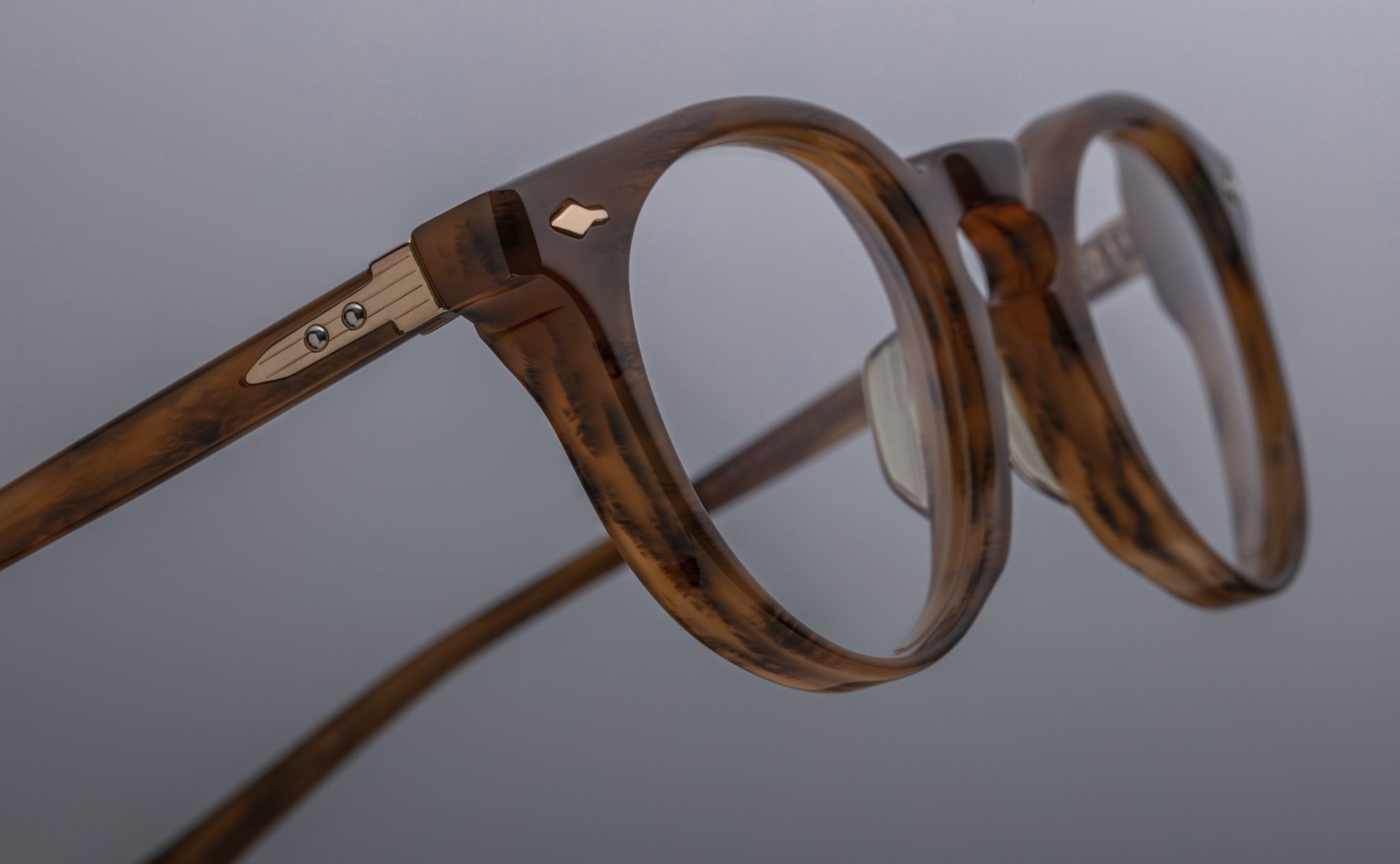 Close-up of Jacques Marie Mage Percier eyeglasses, round tortoiseshell frames, metallic hinges, front angle.