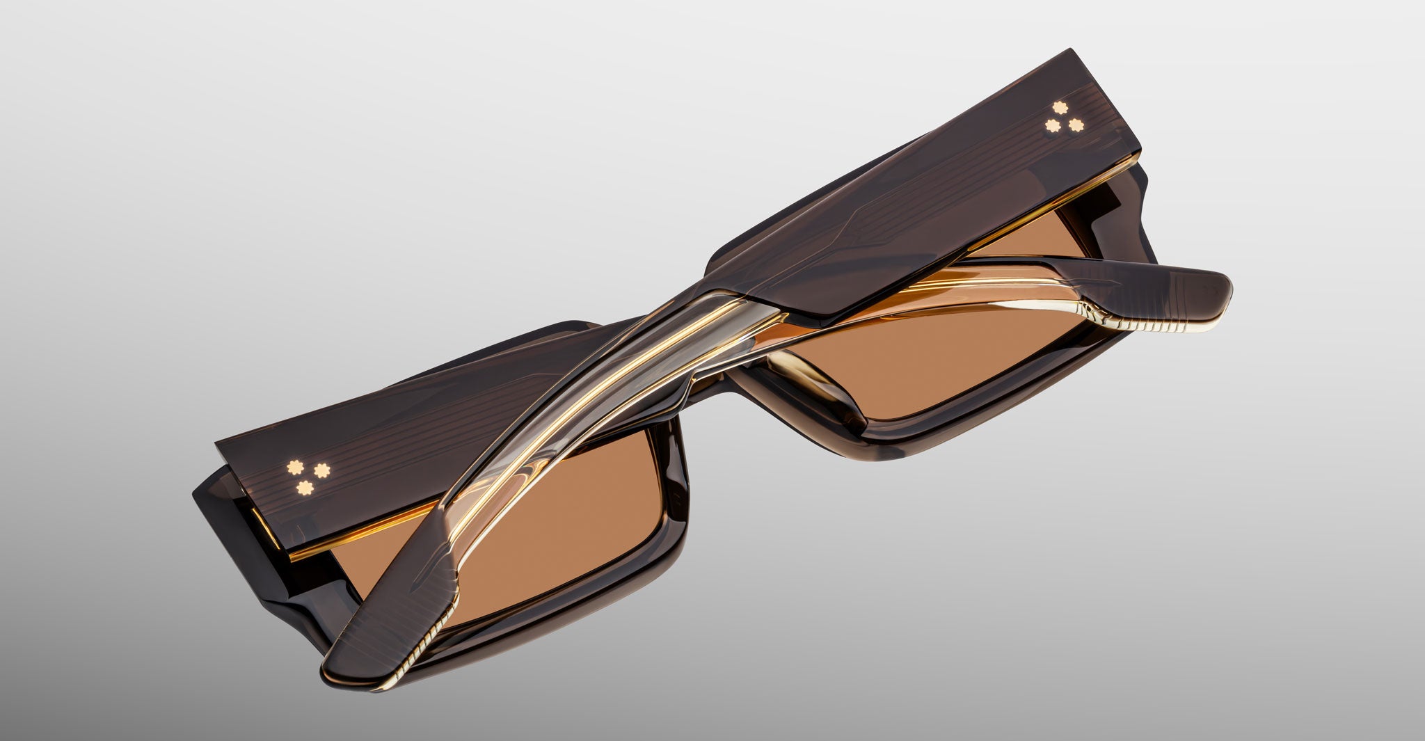 Jacques Marie Mage Quant in London, rectangular translucent brown acetate sunglasses shown from an angled top view, highlighting wide temples with signature metal inlay, bold sculpted rims, and warm brown tinted lenses.