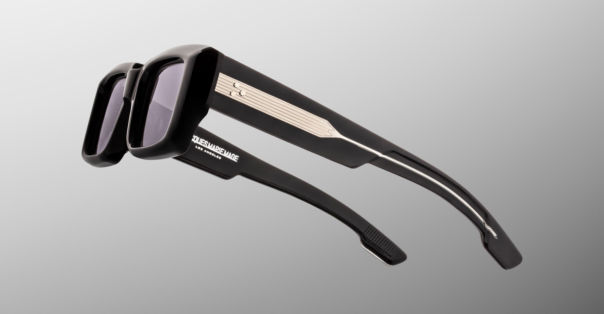 Jacques Marie Mage Quant in Shadow, rectangular black acetate sunglasses shown from a rear side angle, highlighting wide temples with signature metal inlay, sculpted temple tips, and dark tinted lenses.
