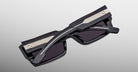 Jacques Marie Mage Quant in Shadow, rectangular black acetate sunglasses shown from an angled top view, highlighting wide temples with signature metal inlay, bold sculpted rims, and dark tinted lenses.