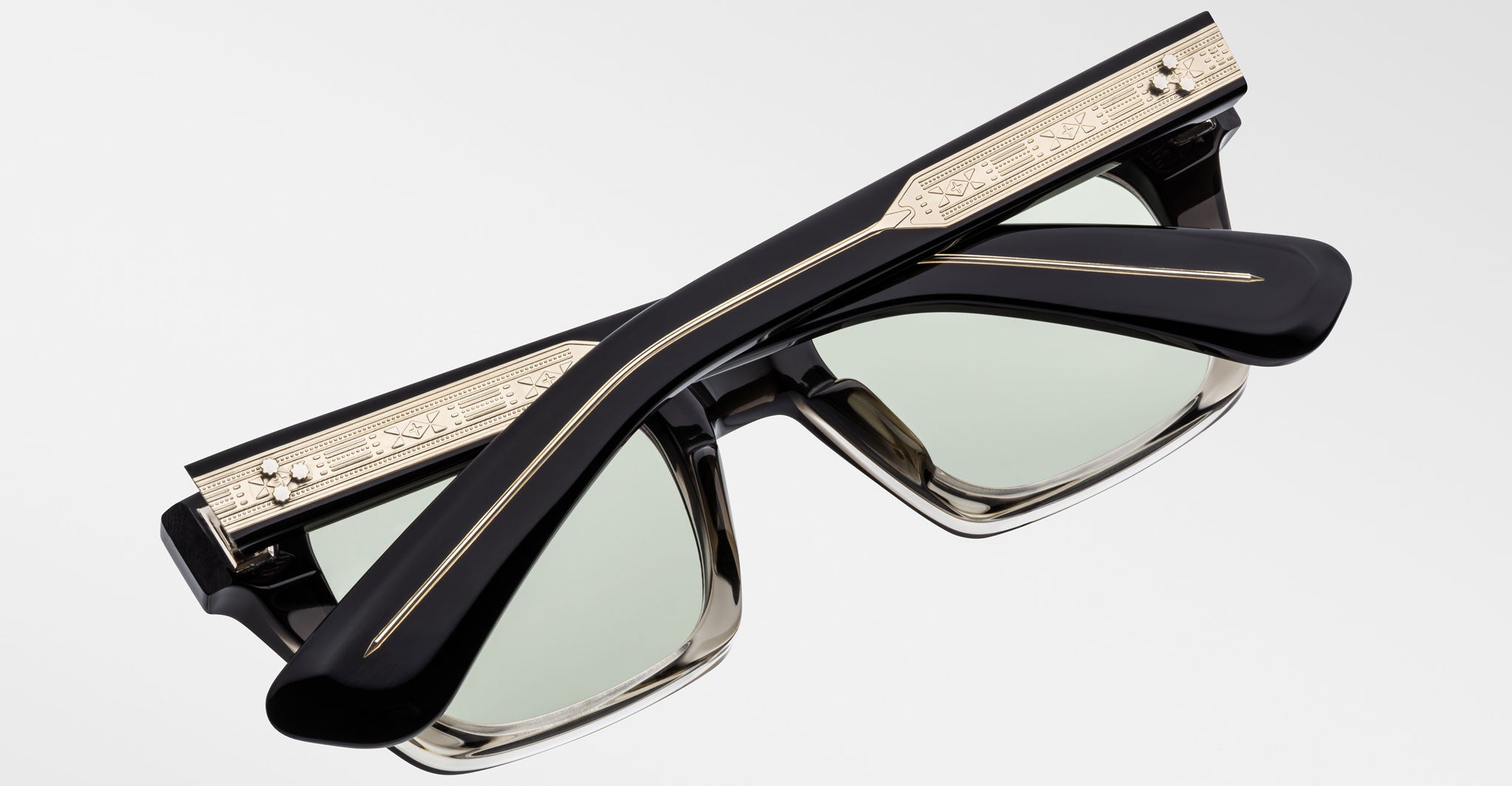 Jacques Marie Mage Quentin sunglasses, black with gold rims and engraved details, shown folded from above.