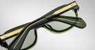 Detailed back view of a pair of Jacques Marie Mage Richard green, thick-framed sunglasses with light green lenses on a plain background