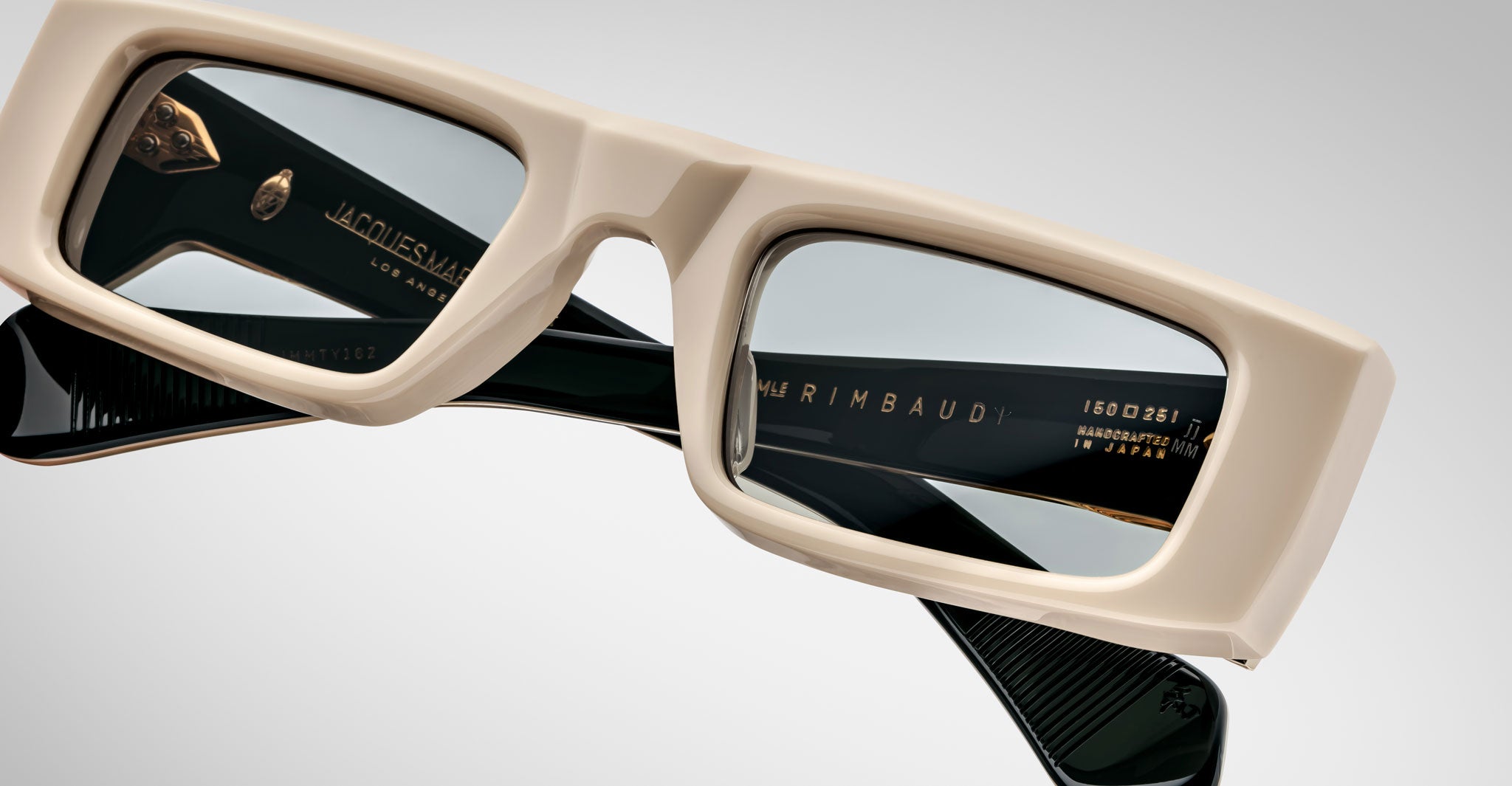 Detailed front view of the Jacques Marie Mage Rimbaud sunglass in cream color with light grey lenses on a white background