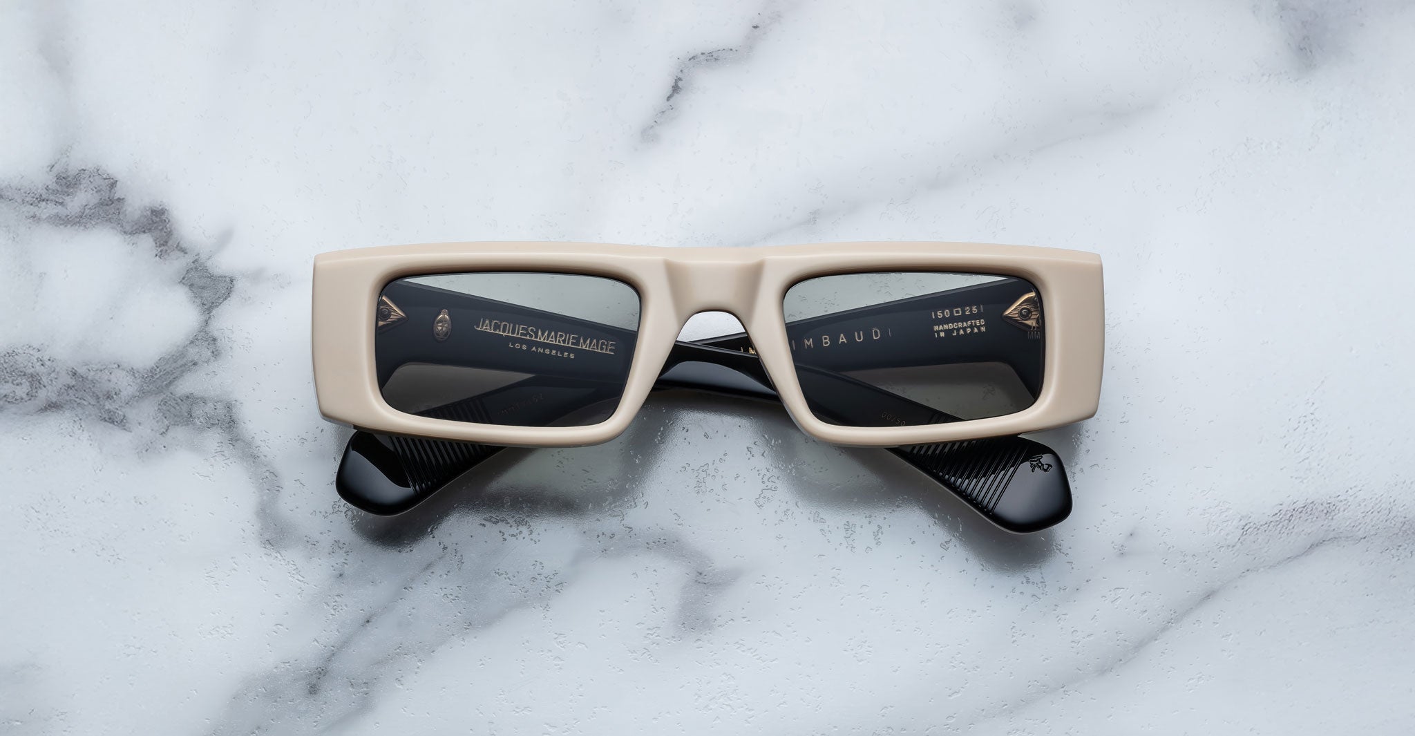 Front view of the Jacques Marie Mage Rimbaud sunglass in cream color with light grey lenses on a white marbled with grey veining background