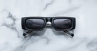 Front view of the Jacques Marie Mage Rimbaud sunglass in black color with grey lenses on a white marbled with grey veining background