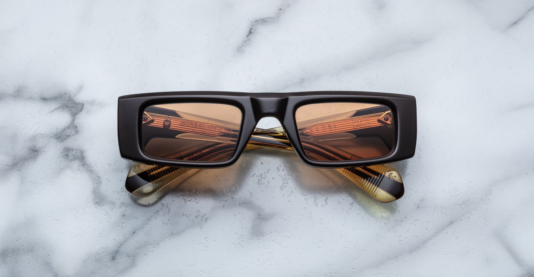 Front view of the Jacques Marie Mage Rimbaud sunglass in walnut color with orange lenses on a white marbled with grey veining background