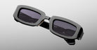Jacques Marie Mage Ryder in Black, rectangular black acetate sunglasses shown from a close angled front view, featuring thick sculpted rims, a low-profile bridge, and dark tinted lenses.