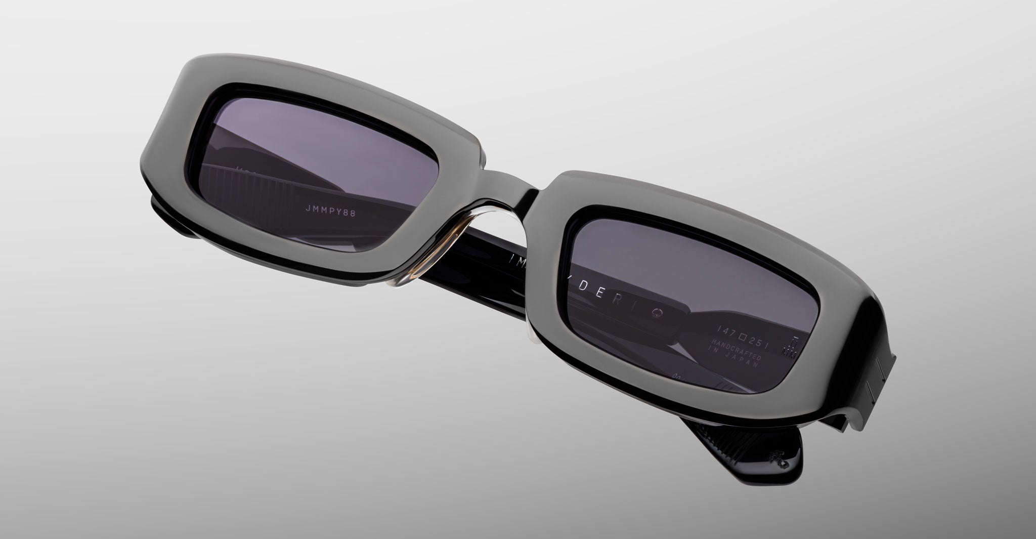 Jacques Marie Mage Ryder in Black, rectangular black acetate sunglasses shown from a close angled front view, featuring thick sculpted rims, a low-profile bridge, and dark tinted lenses.