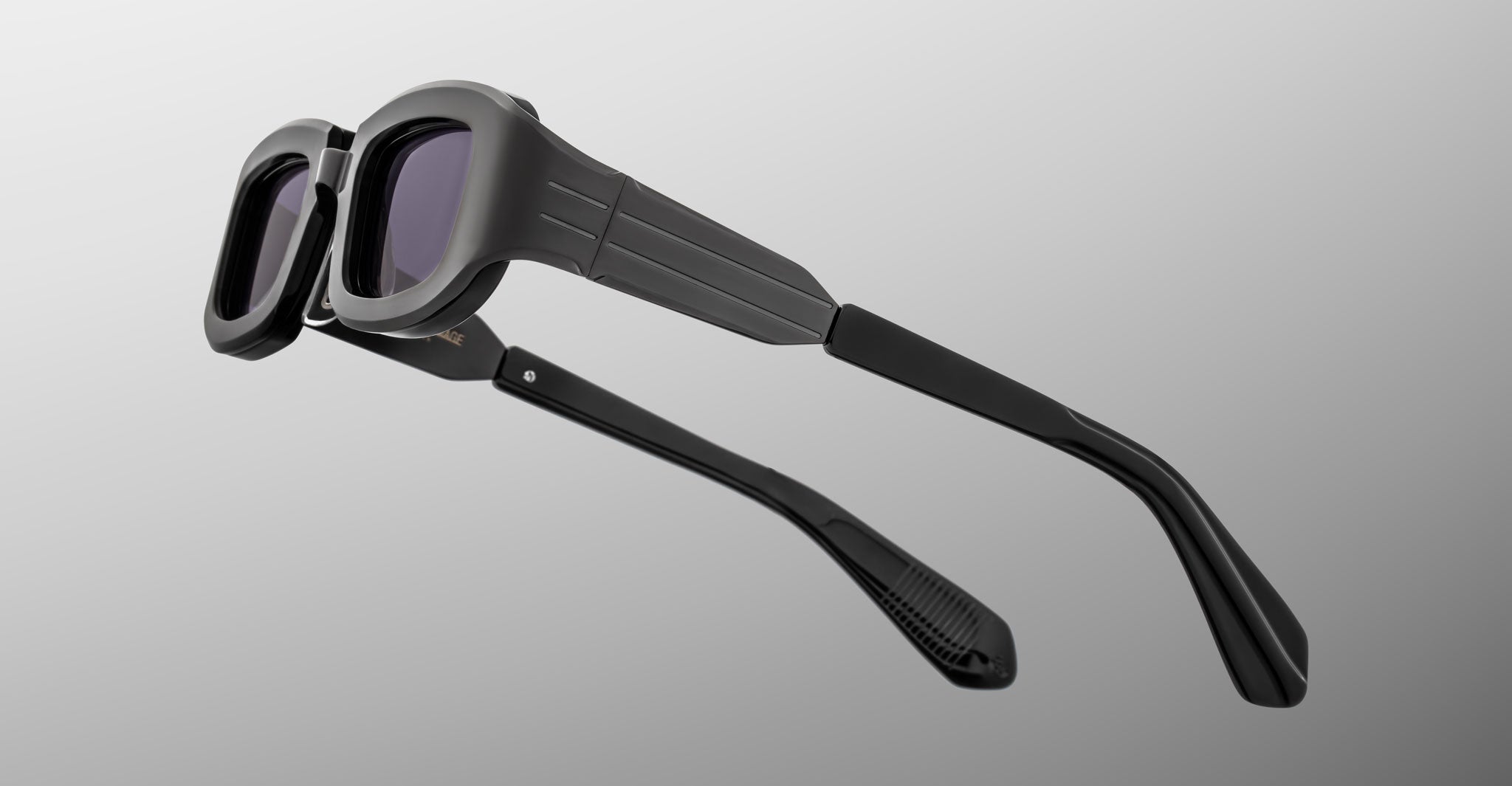 Jacques Marie Mage Ryder in Black, rectangular black acetate sunglasses shown from a rear side angle, highlighting wide temples with stepped detailing, sculpted temple tips, and dark tinted lenses.