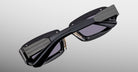 Jacques Marie Mage Ryder in Black, rectangular black acetate sunglasses shown from an angled top view, highlighting thick sculpted rims, wide temples with stepped detailing, and dark tinted lenses.