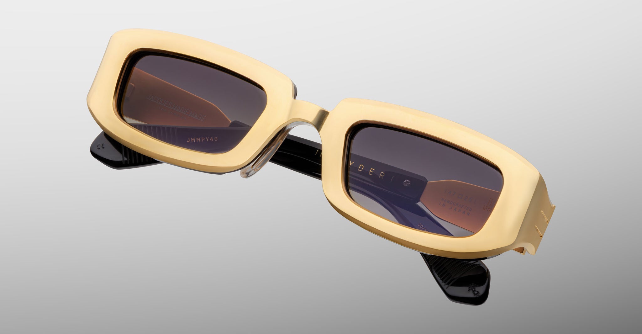 Jacques Marie Mage Ryder in Gold, rectangular gold-tone acetate sunglasses shown from a close angled front view, featuring thick sculpted rims, a low-profile bridge, and gradient tinted lenses.