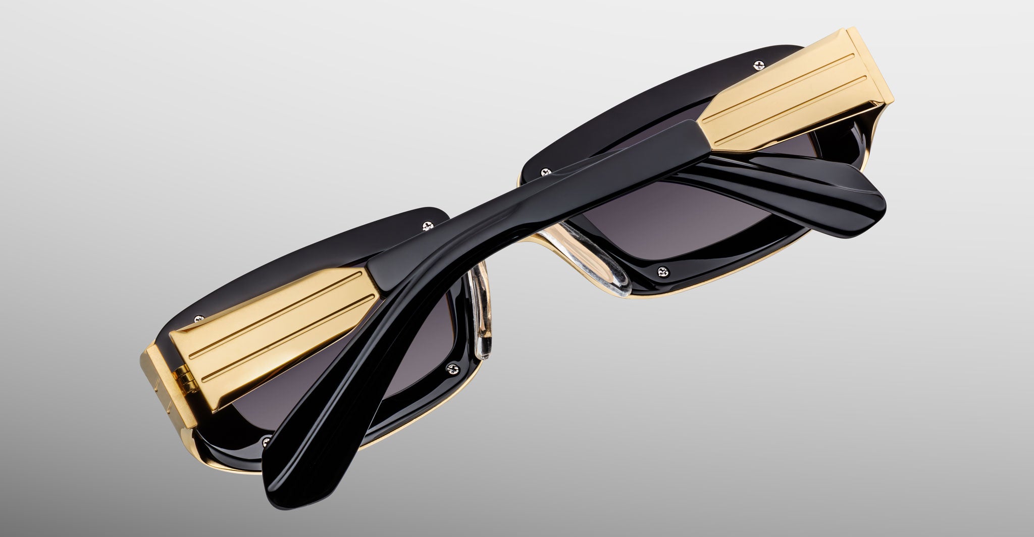 Jacques Marie Mage Ryder in Gold, rectangular gold-tone acetate sunglasses shown from an angled top view, highlighting thick sculpted rims, wide temples with stepped detailing, and gradient tinted lenses.