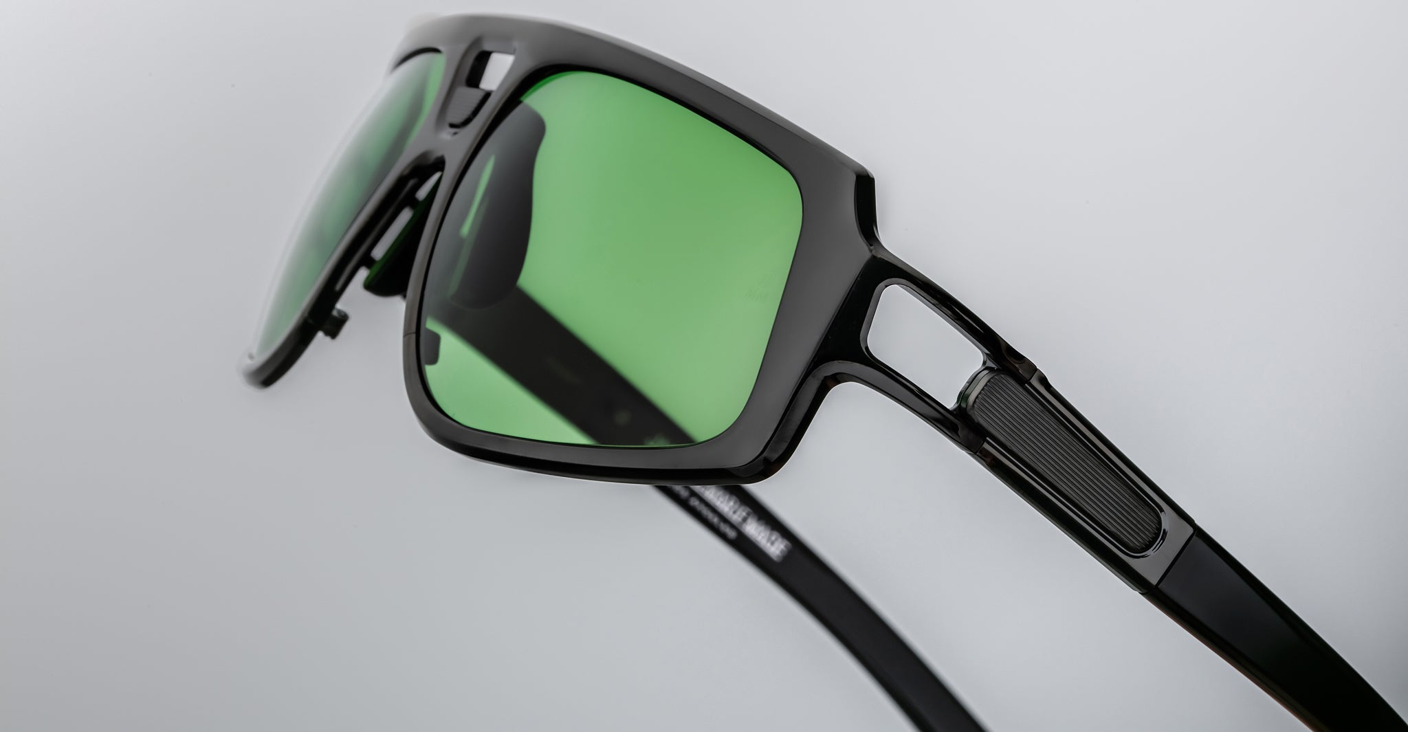Close-up of Jacques Marie Mage Scarface sunglasses, black frames with green lenses, product viewed from the front.