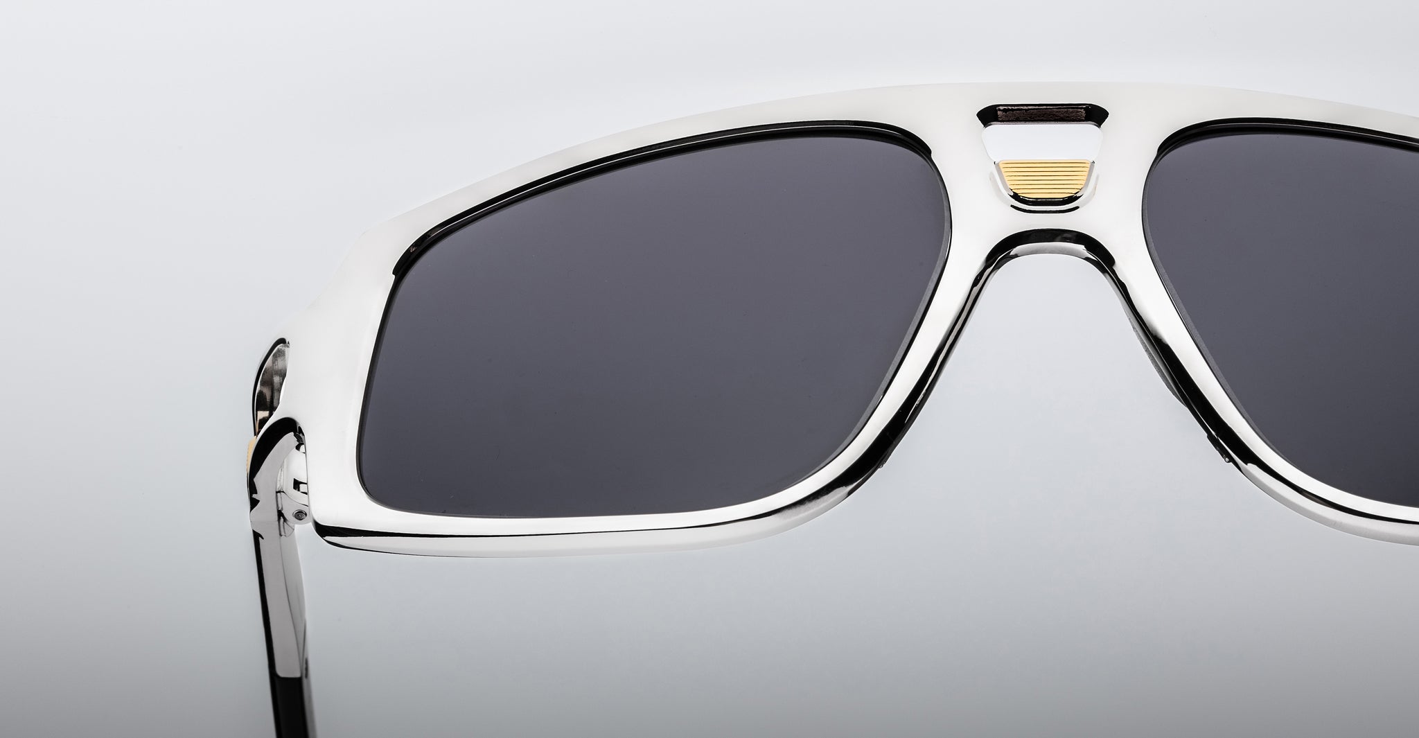 Close-up of Jacques Marie Mage Scarface sunglasses with black lenses, silver frame, and gold accent detailing.