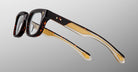 The Jacques Marie Mage Stewart features thick rectangular tortoiseshell frames, clear lenses, and gold accents on the arms, displayed against a plain light gray background.