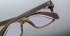 Close-up of Jacques Marie Mage Torino eyeglasses by Jacques Marie Mage, showcasing bold rectangular frames in glossy handcrafted acetate with clear lenses, displayed against a neutral background.