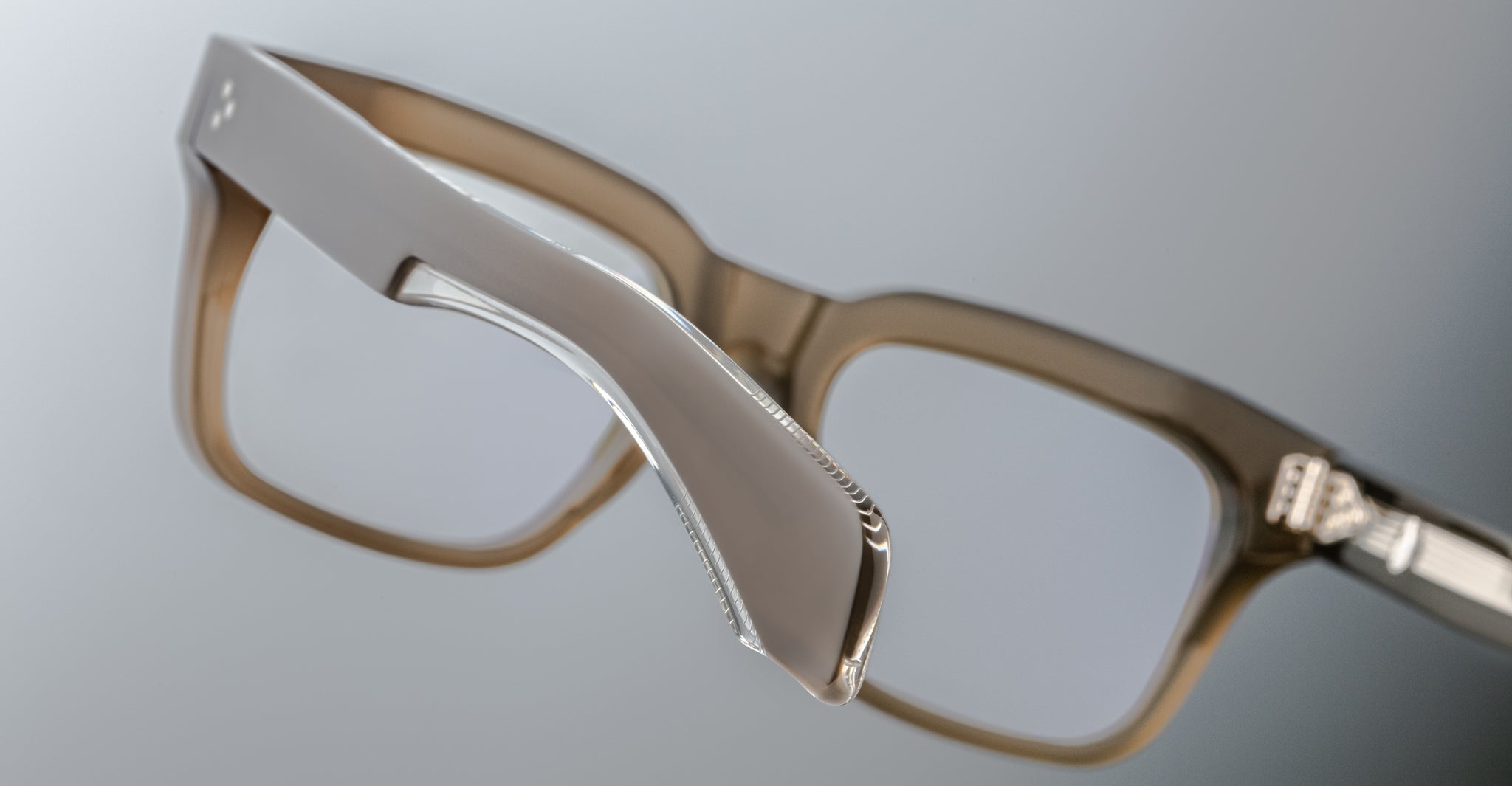 Close-up of Jacques Marie Mage Torino eyeglass frames by Jacques Marie Mage, highlighting the handcrafted acetate frame and hinge against a neutral background.