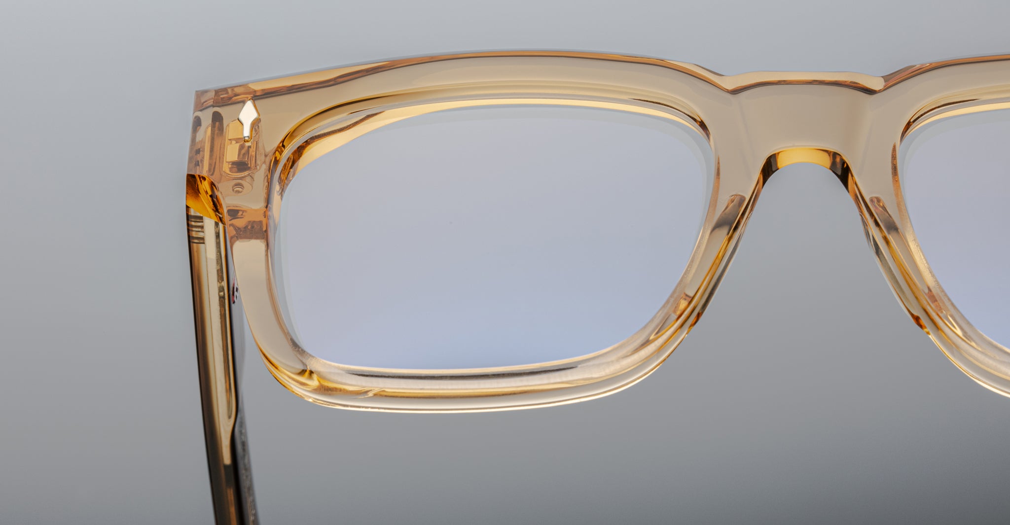 Close-up of the Jacques Marie Mage Torino: bold, handcrafted rectangular eyeglass frames in light brown acetate, set against a neutral background.