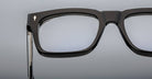 Close-up of the upper left section of bold rectangular Jacques Marie Mage Torino eyewear, handcrafted from acetate, featuring a metallic arrow detail near the hinge.