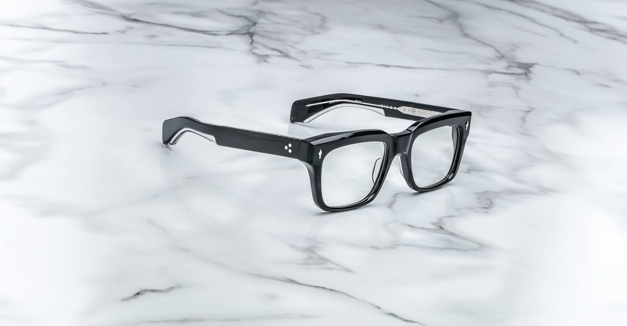 Jacques Marie Mage Torino bold rectangular eyeglass frames, handcrafted in acetate by Jacques Marie Mage, are displayed elegantly on a white marble surface with gray veining.