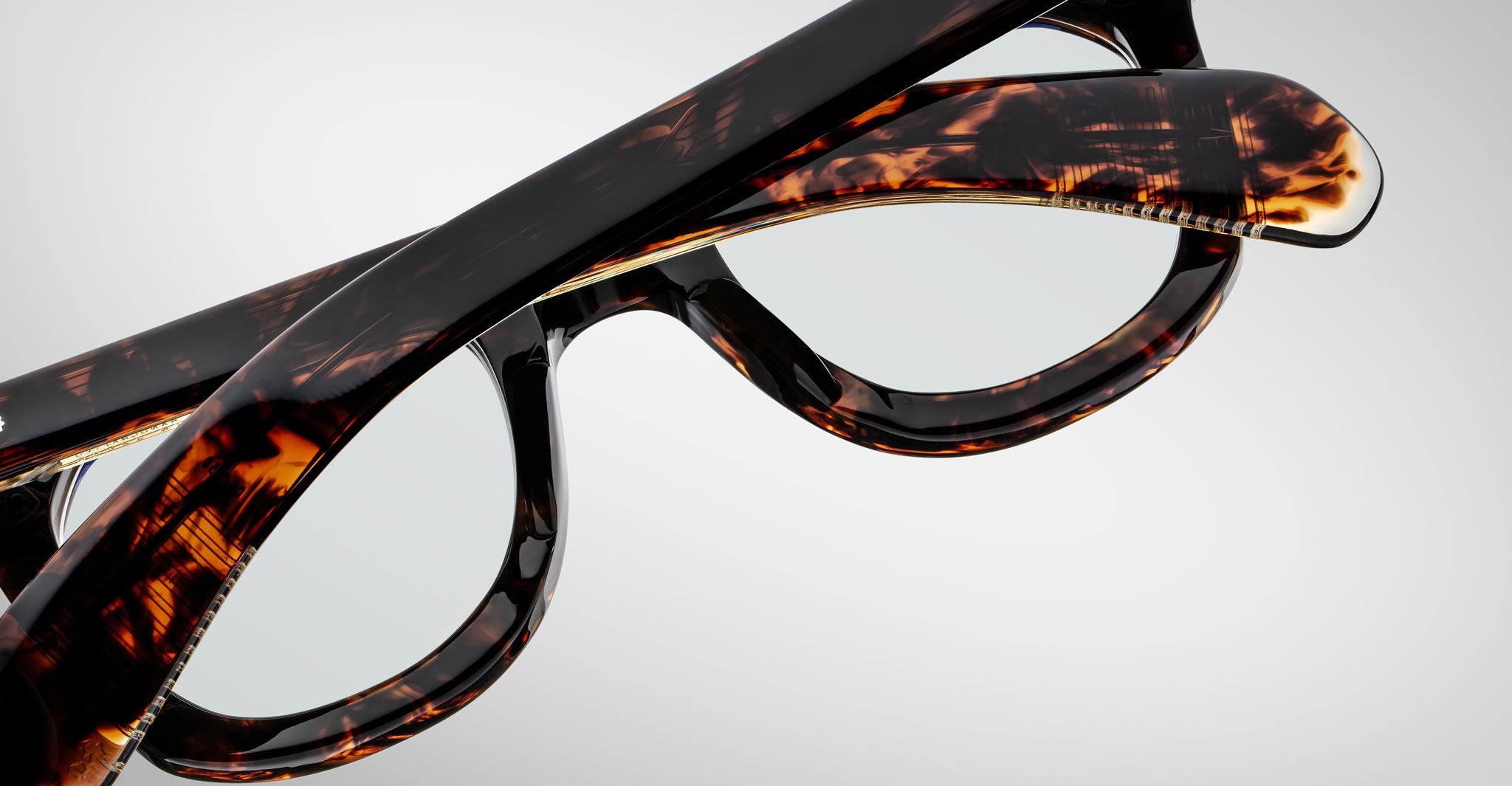 Close-up of Jacques Marie Mage Vendome optical frames with crossed temples, handcrafted in Japan, shown against a plain light background.