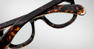 Close-up of Jacques Marie Mage Vendome optical frames with crossed temples, handcrafted in Japan, shown against a plain light background.