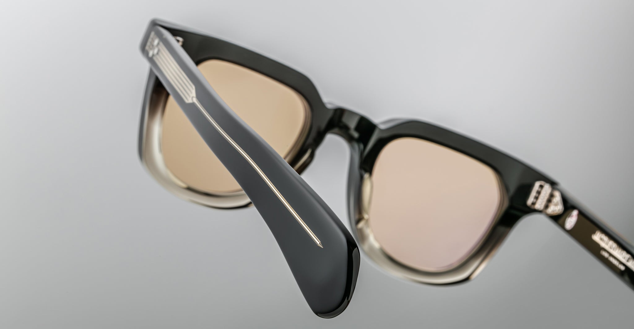 Close-up of Jacques Marie Mage Vendome black and translucent optical frames with light brown tinted lenses, shown at an angle to highlight the expertly handcrafted temple and hinge details.