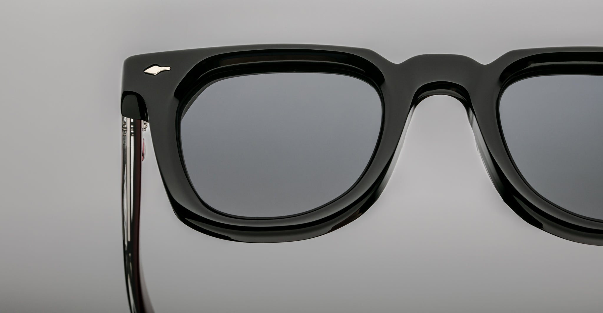 Close-up of the top half of Jacques Marie Mage Vendome sunglasses in black, featuring dark lenses and a small silver logo on the upper left frame. Expertly handcrafted in Japan for outstanding quality.