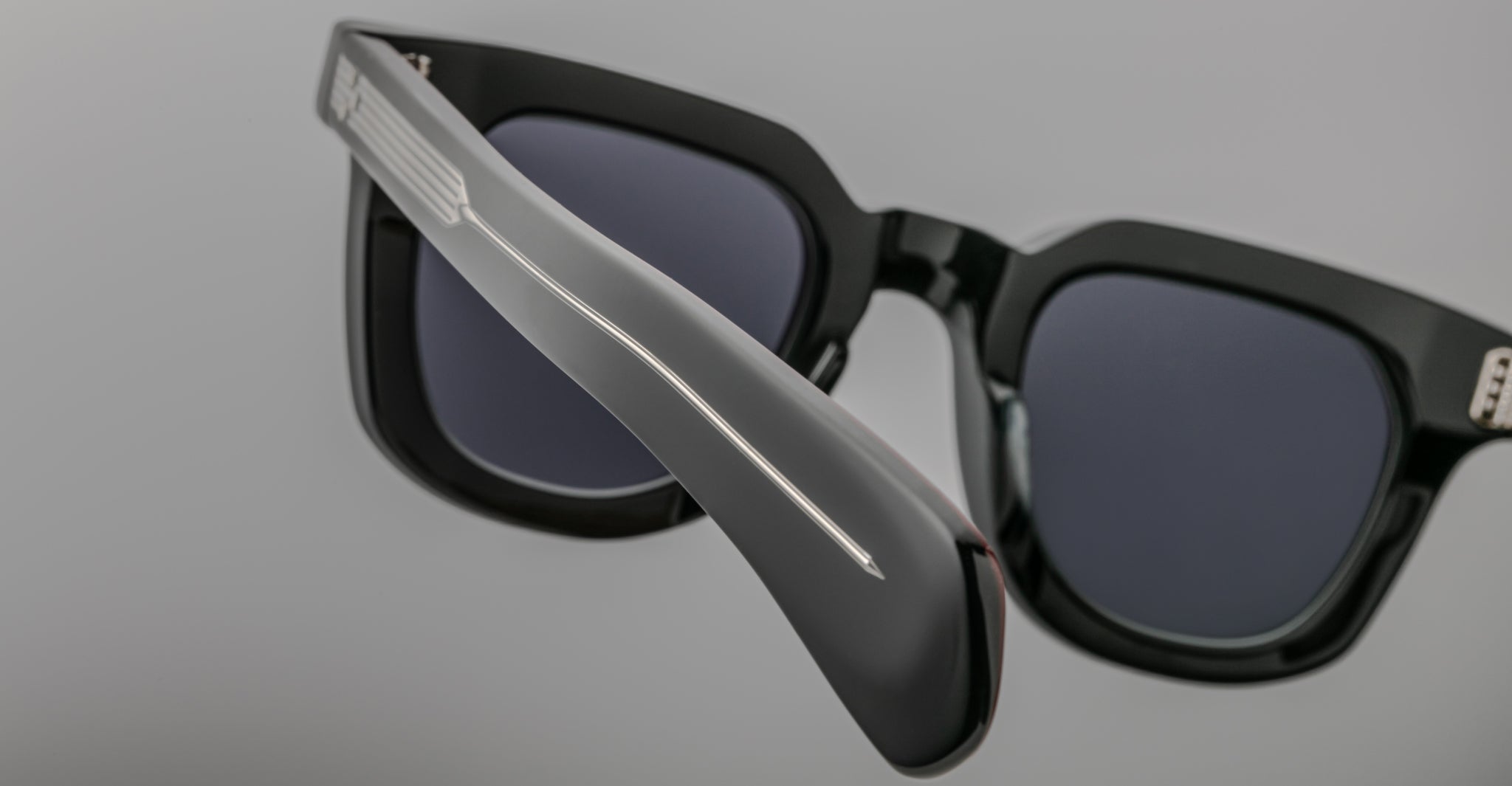 Close-up of Jacques Marie Mage Vendome black sunglasses with dark lenses, showcasing their thick arms and hinges—expertly handcrafted in Japan by Jacques Marie Mage.