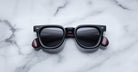 Jacques Marie Mage Vendome sunglasses featuring black square frames, dark lenses, and burgundy arms rest on a white marble surface. Handcrafted in Japan by Jacques Marie Mage.