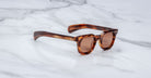 Jacques Marie Mage Vendome sunglasses by Jacques Marie Mage, handcrafted in Japan with tortoiseshell frames and brown lenses, displayed on a white marble surface.