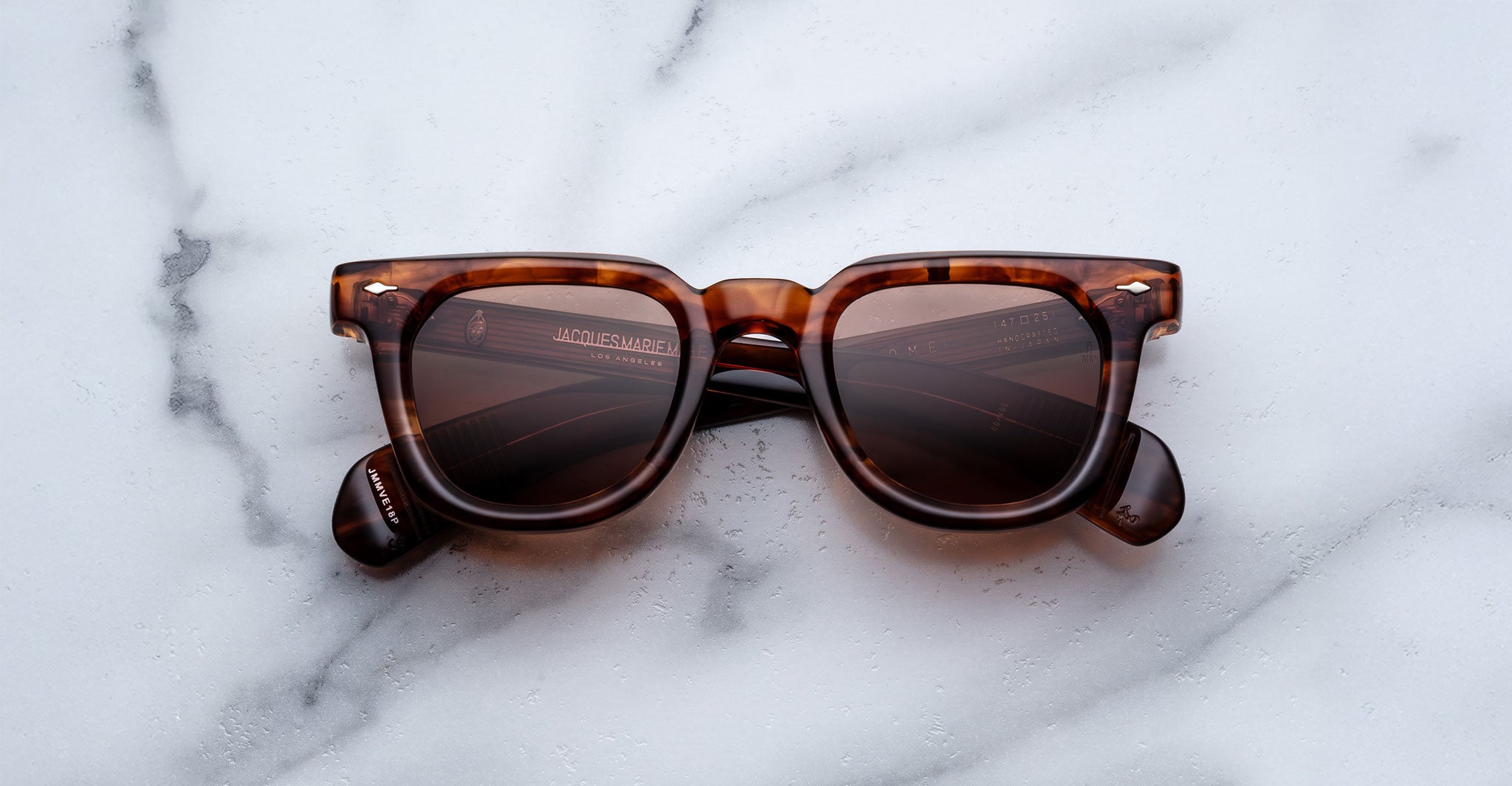 Jacques Marie Mage Vendome tortoiseshell rectangular sunglasses, handcrafted in Japan, rest on a white marble surface.