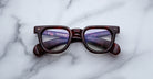 Jacques Marie Mage Vendome brown tortoiseshell optical frames, handcrafted in Japan, are displayed on white marble with gray veins.
