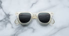 Jacques Marie Mage Vendome sunglasses by Jacques Marie Mage, featuring clear frames and dark lenses, handcrafted in Japan, displayed on a white and gray marble surface.