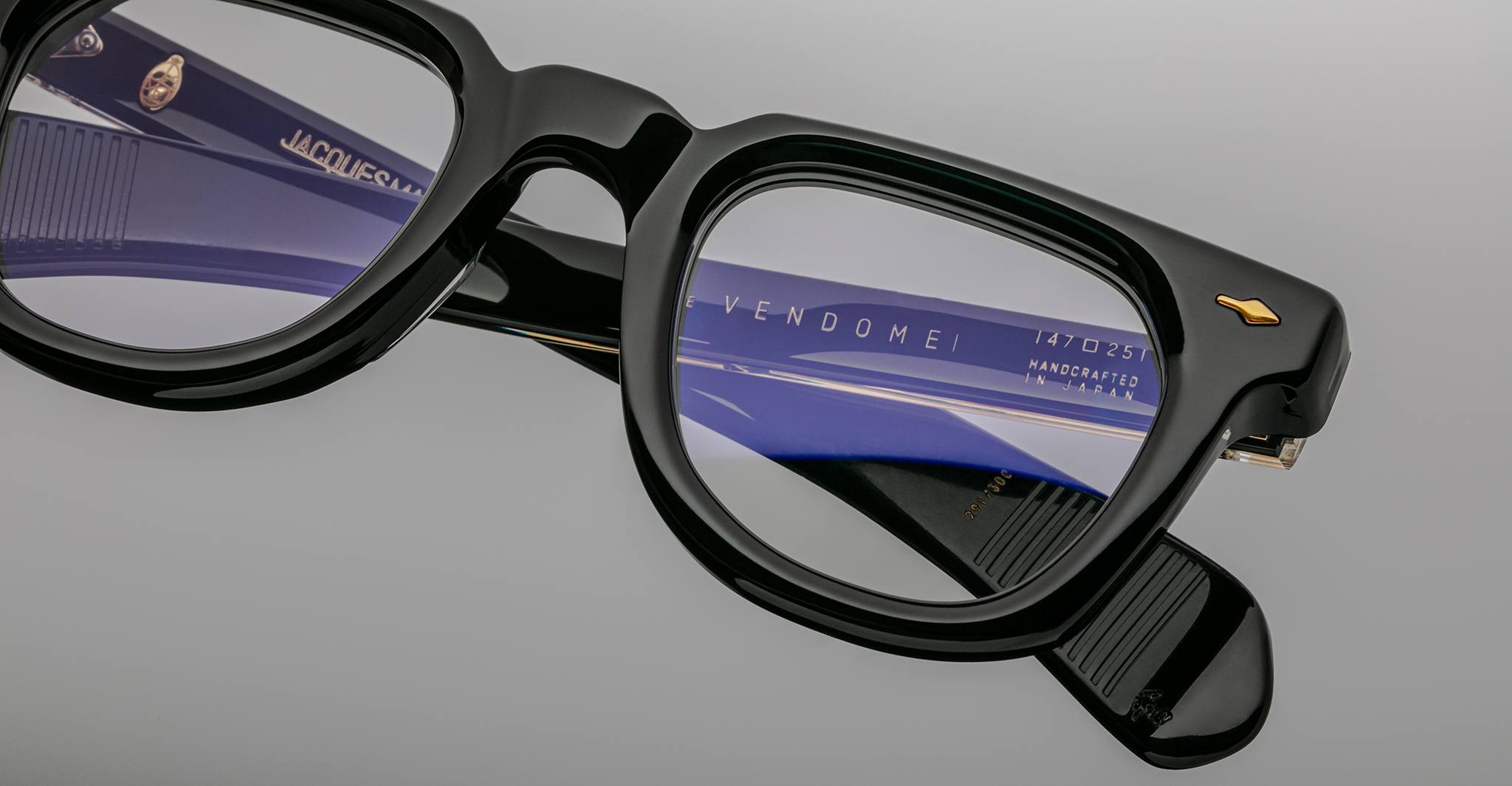Close-up of Jacques Marie Mage Vendome optical frames showing "handcrafted in Japan" and "Handcrafted in France" engraved on the inner temple.