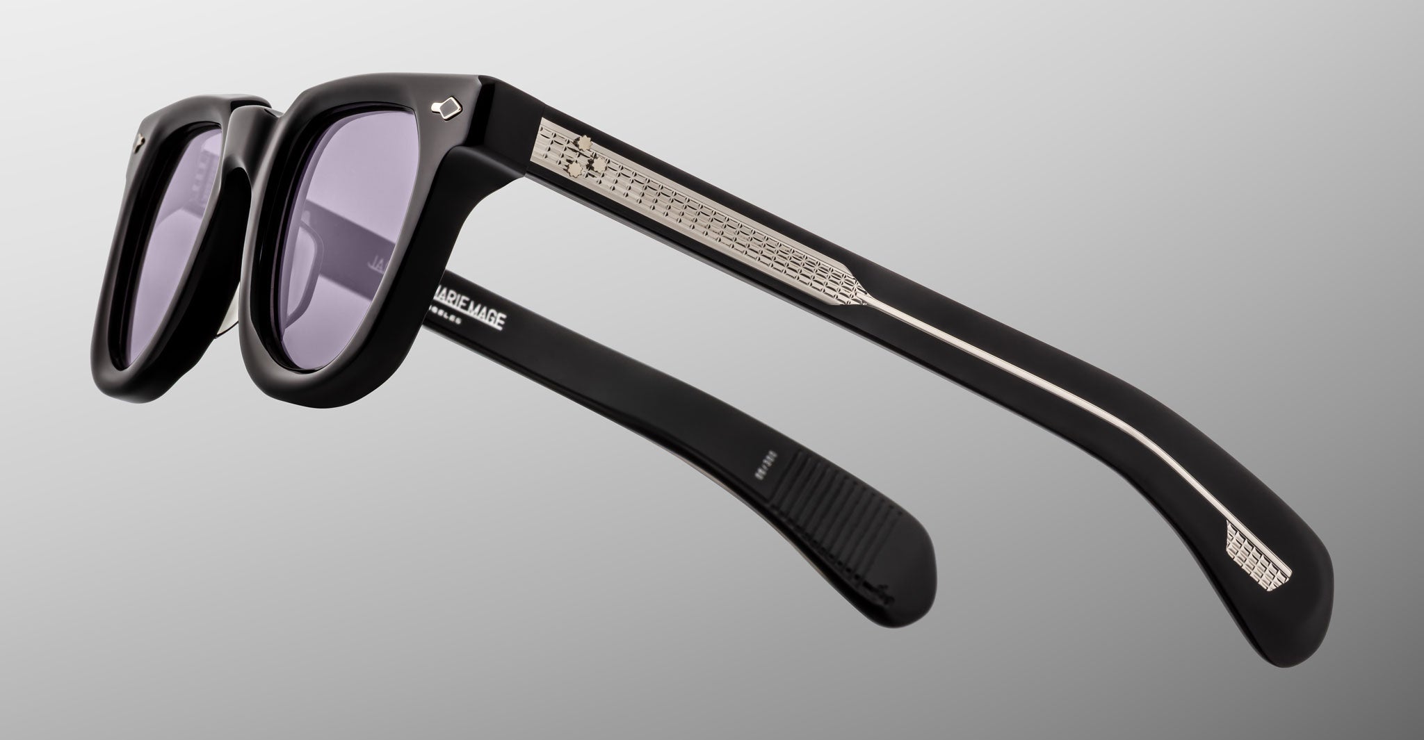 Close-up of Jacques Marie Mage Vendome sunglasses in black with silver-accented arms, handcrafted in Japan, displayed on a light gray background.