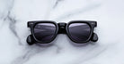 Jacques Marie Mage Vendome in Fumee black rectangular sunglasses with dark lenses, viewed from above.