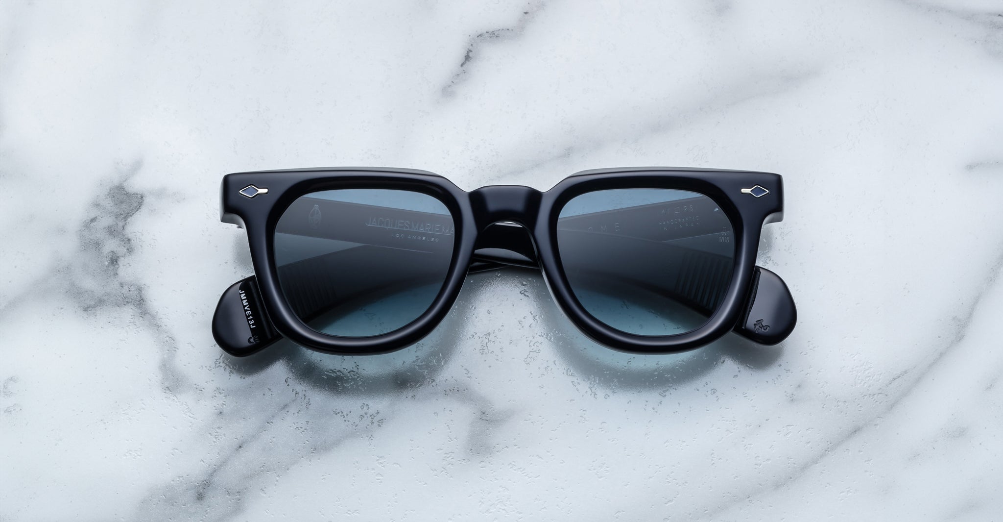 Jacques Marie Mage Vendome black square-framed sunglasses with dark lenses, handcrafted in Japan, displayed on a white marble surface.