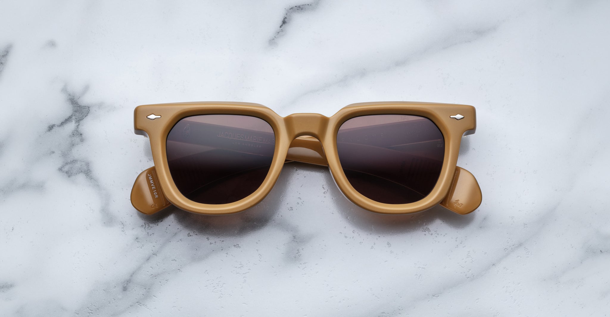 Tan square-framed Jacques Marie Mage Vendome sunglasses with dark lenses by Jacques Marie Mage, handcrafted in Japan, shown on a white marble surface.