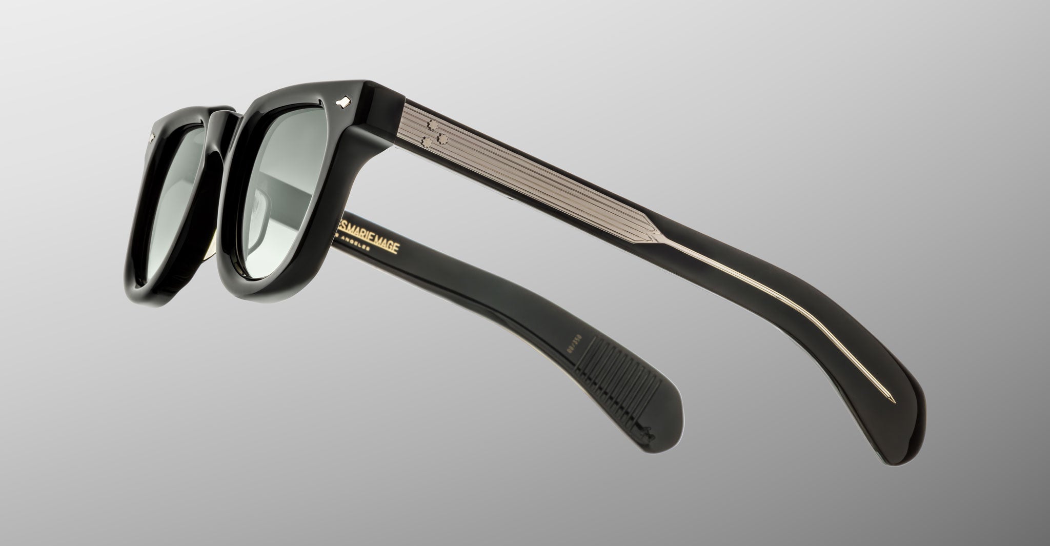 The Jacques Marie Mage Vendome sunglasses feature a black rectangular design with dark lenses, thick frames, and metallic arm accents. Handcrafted in Japan by Jacques Marie Mage, they're showcased against a plain gray background.