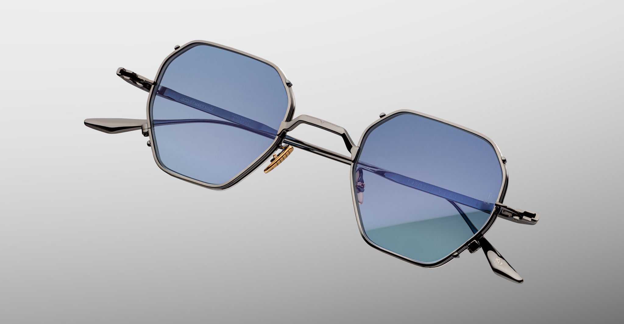 Jacques Marie Mage Verlaine hexagonal sunglasses with blue lenses and thin metal frames, shown from a front-facing angle.