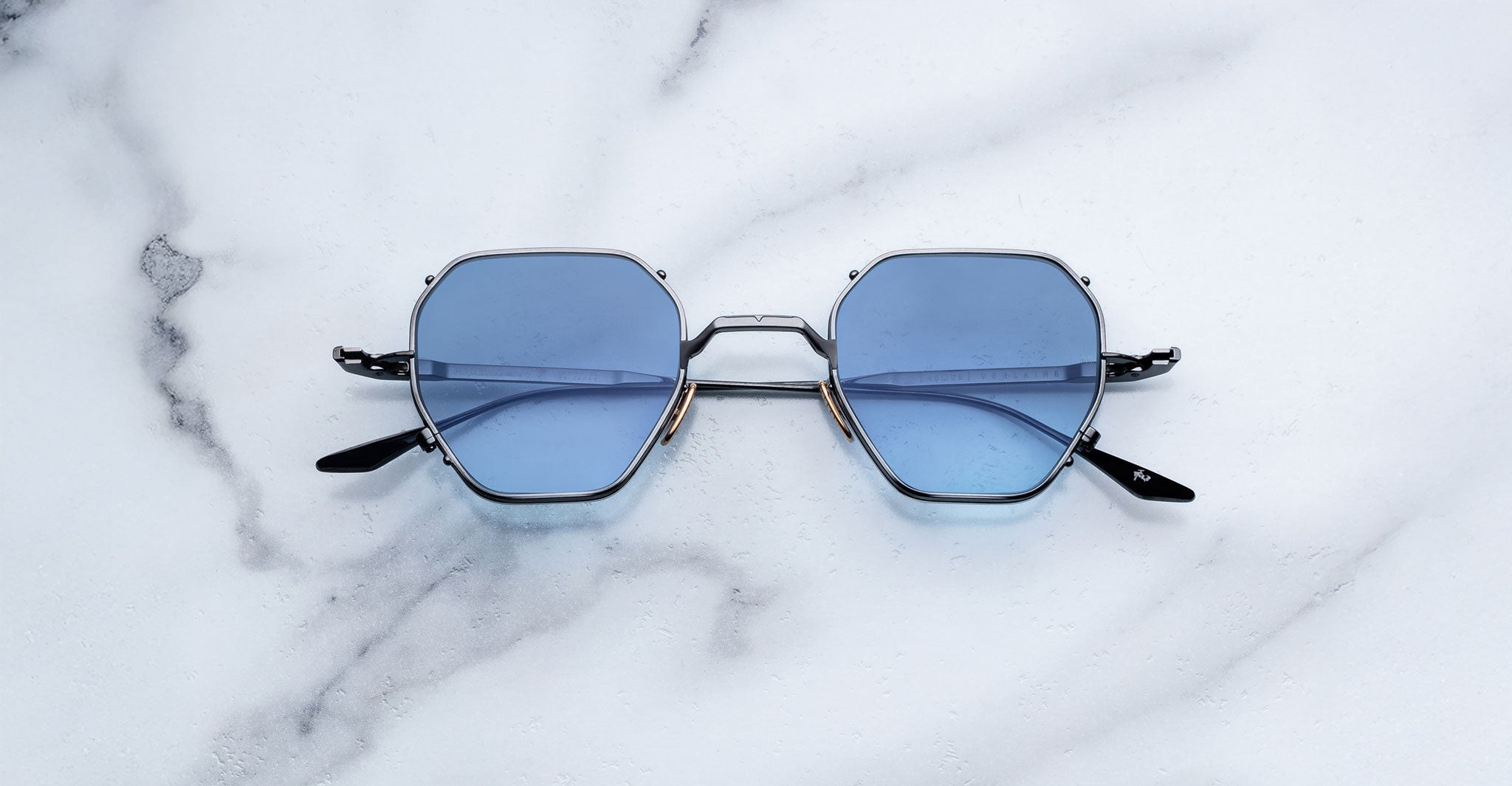 Jacques Marie Mage Verlaine sunglasses, blue hexagonal lenses, thin black frames, front view.