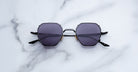 Jacques Marie Mage Verlaine sunglasses with a black hexagonal frame and dark lenses, shown from the front angle.