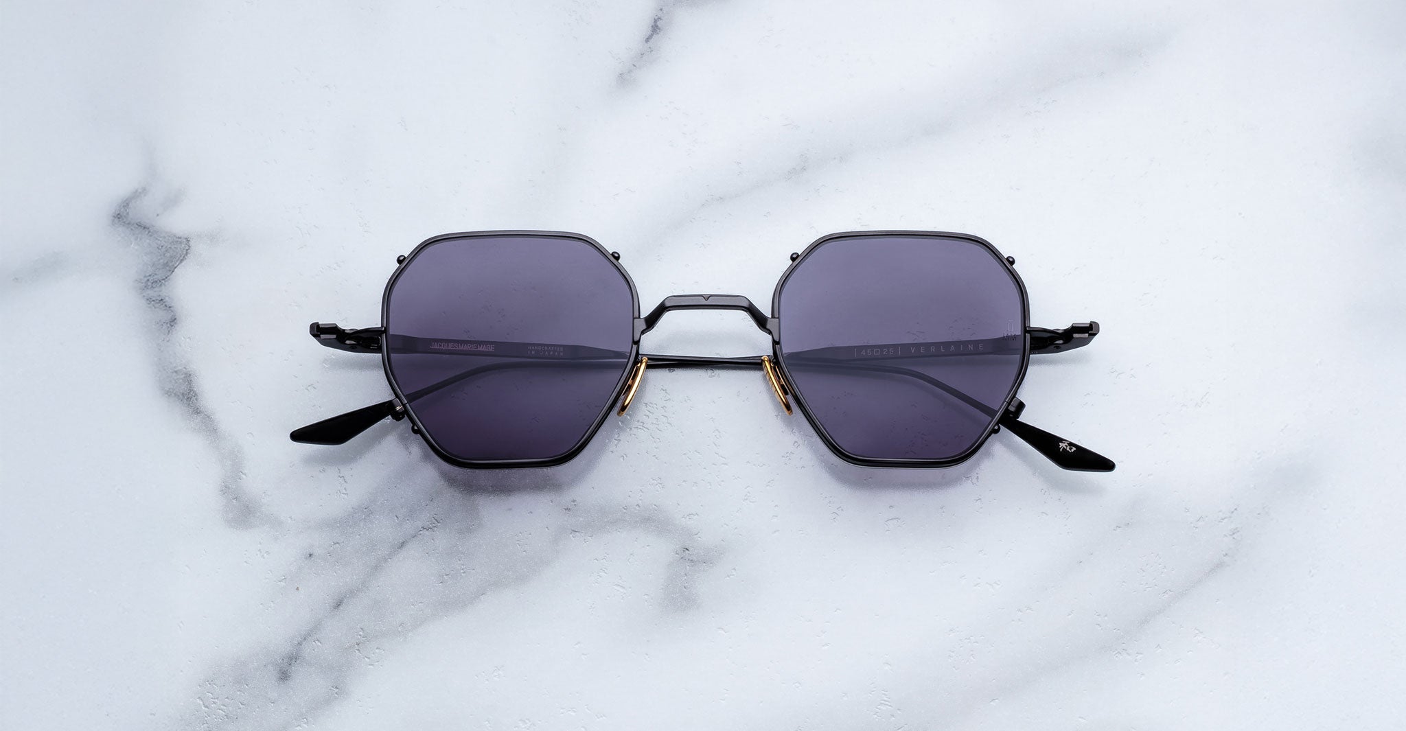 Jacques Marie Mage Verlaine sunglasses with a black hexagonal frame and dark lenses, shown from the front angle.