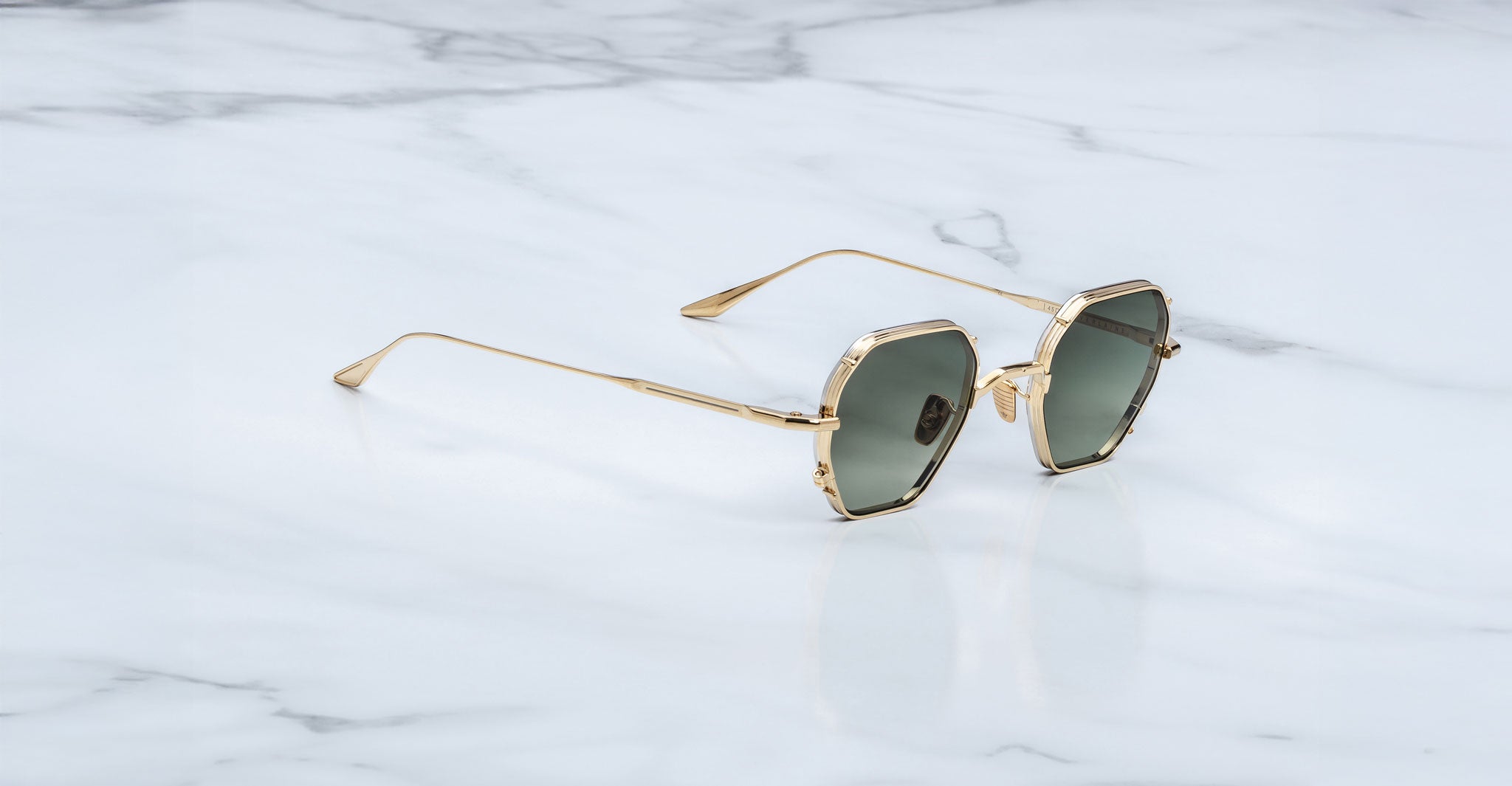 Jacques Marie Mage Verlaine gold hexagonal sunglasses with polarised lenses, shown in a top-down view.