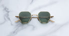 Jacques Marie Mage Verlaine sunglasses with gold hexagonal frames and dark lenses shown from above.