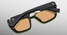 Jacques Marie Mage Walker black rectangular eyeglasses with amber-tinted lenses, viewed from above.