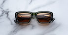 Jacques Marie Mage Walker black rectangular sunglasses with polarized brown lenses, shown from above.